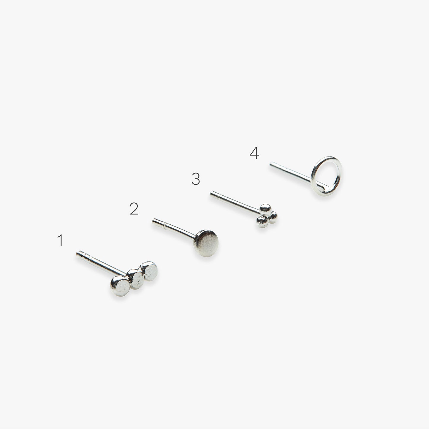 Set of silver stud earrings on a white background