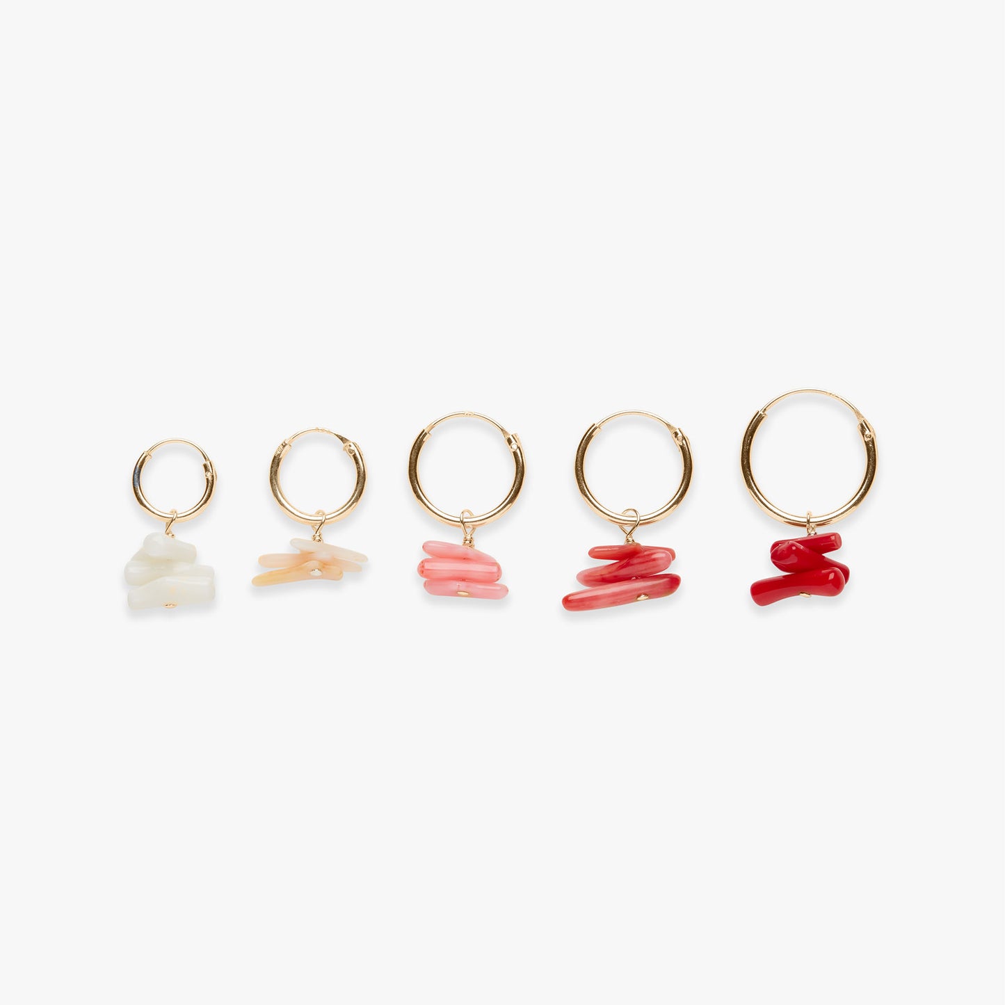 Set of five gold hoop earrings with different colored stones on a white background