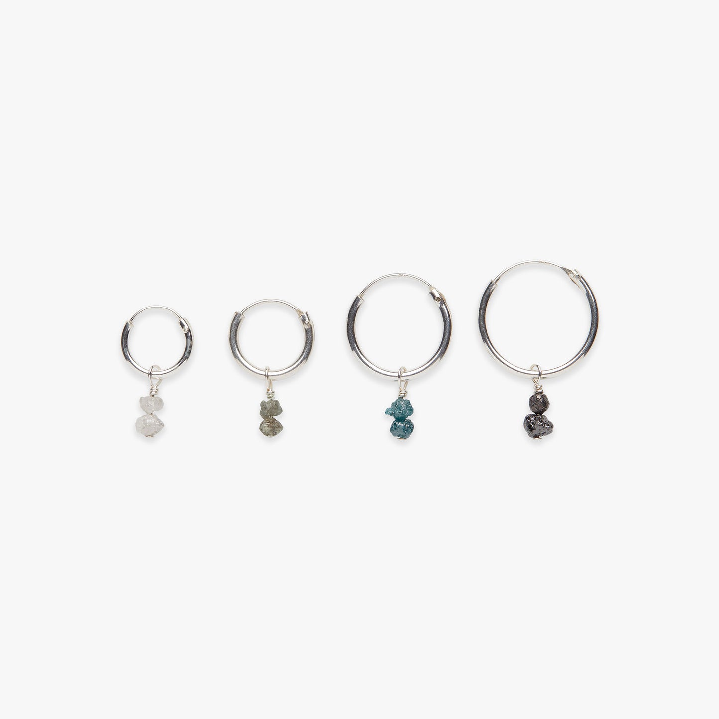 Four silver hoop earrings with various gemstone drops on a white background