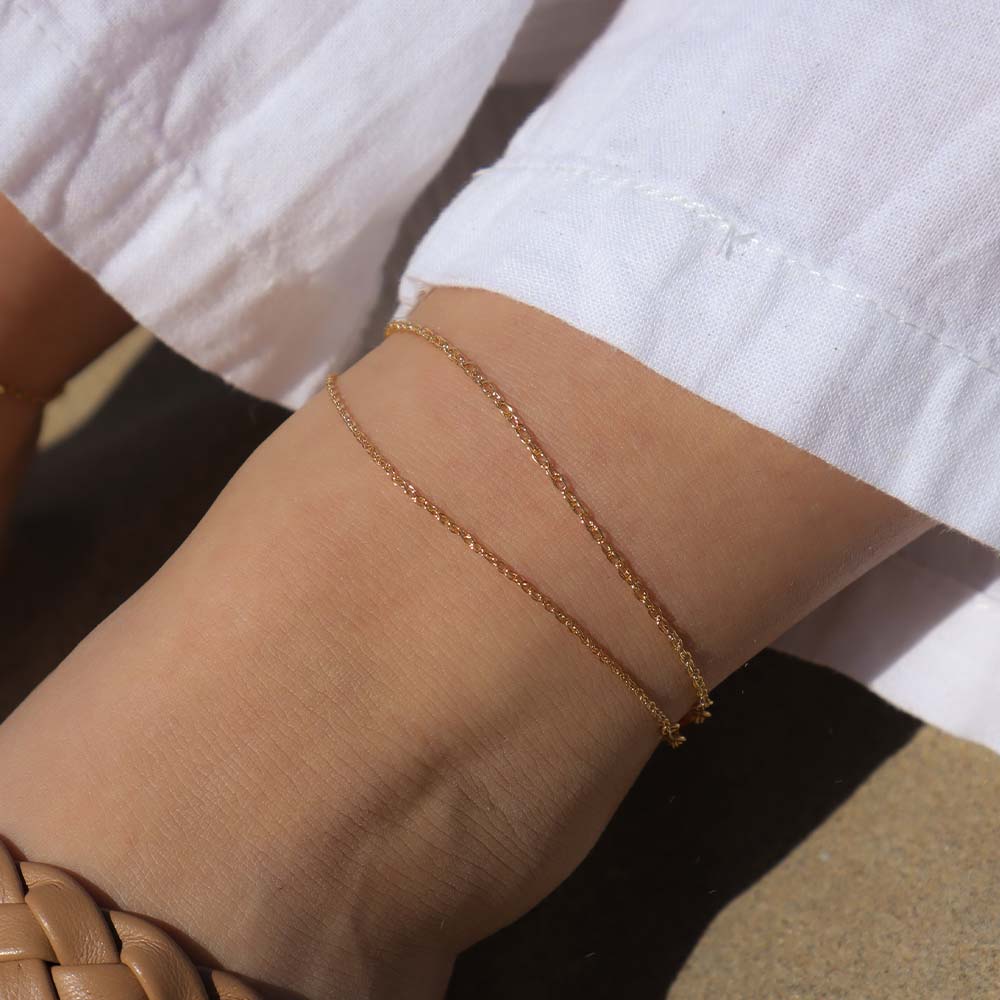 Gold anklets on an ankle with a blurred background