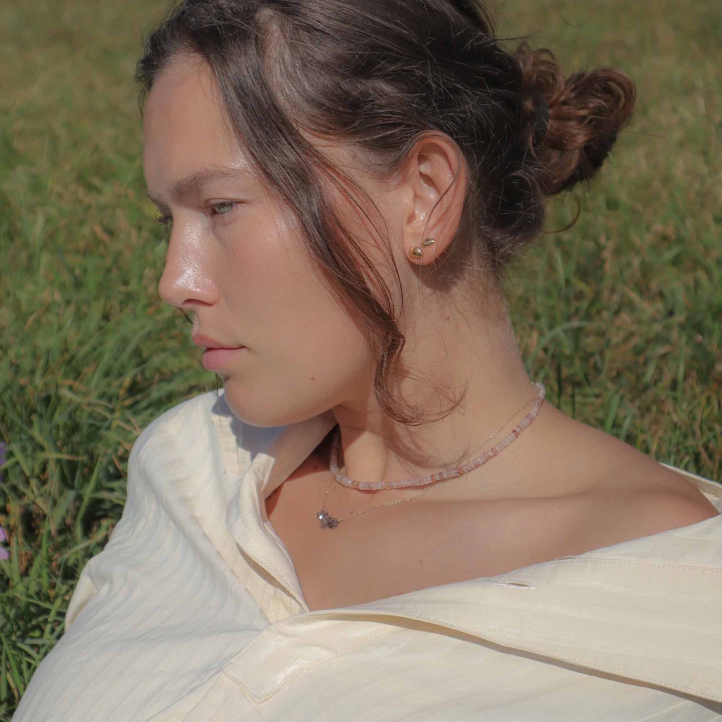 Woman wearing a white garment with a blurred natural background