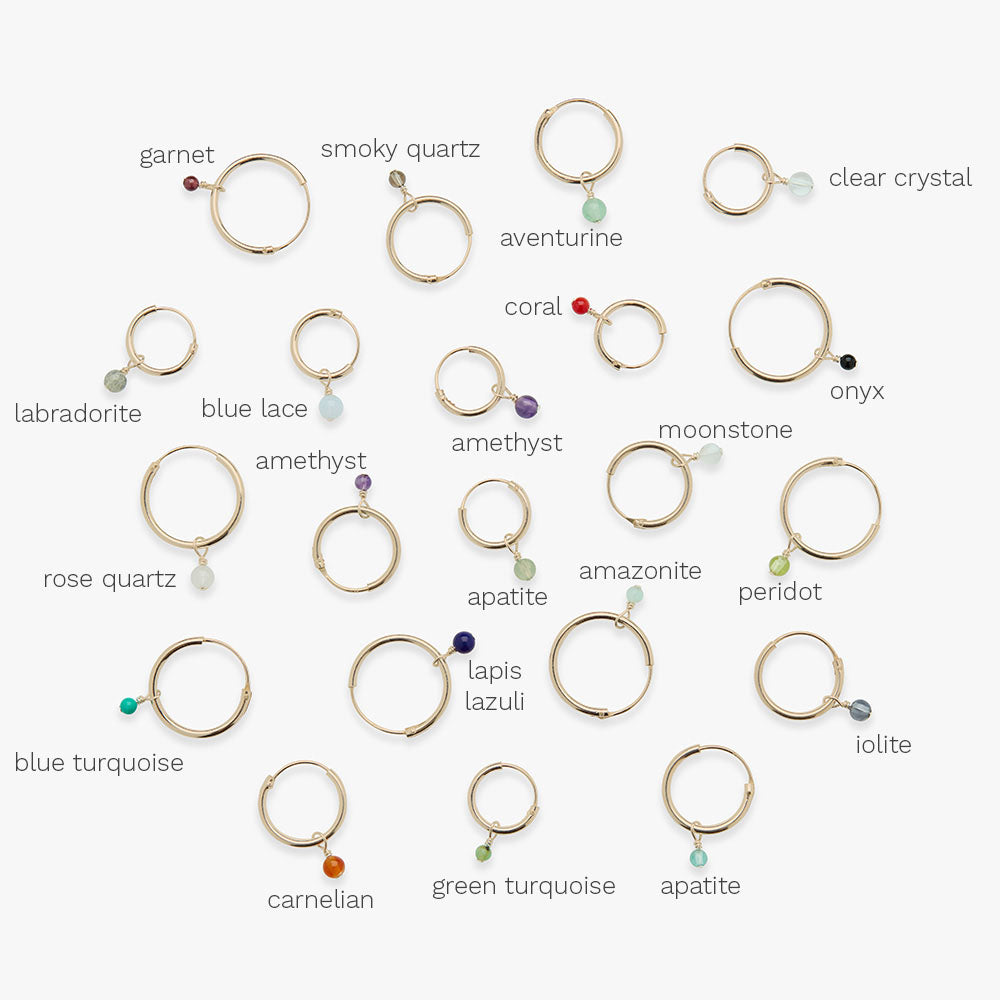 Collection of gold hoop earrings with gemstone beads on a white background