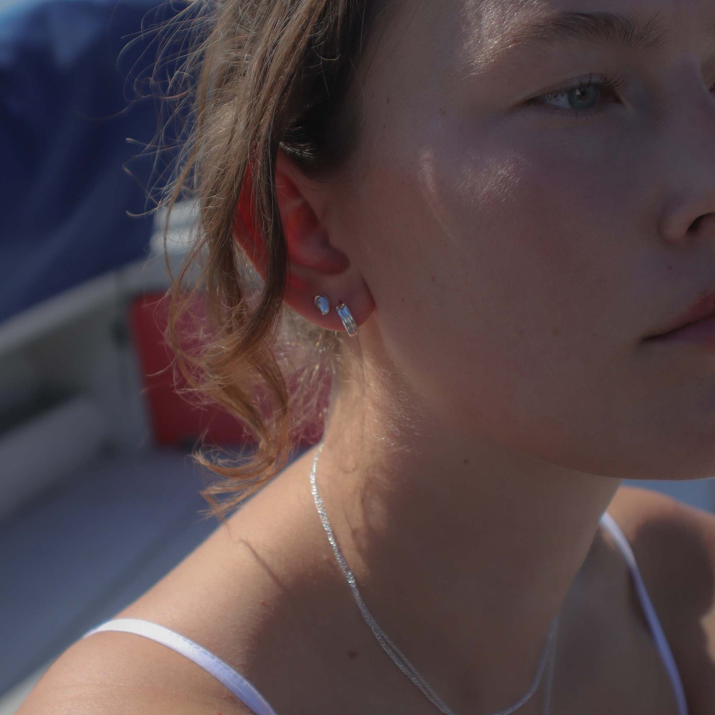 Close-up of a person wearing earrings with a blurred background