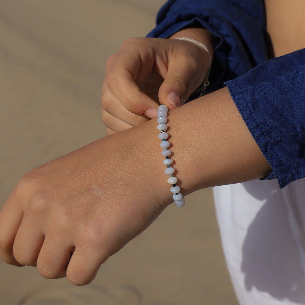 Person wearing a bracelet on a blurred natural background