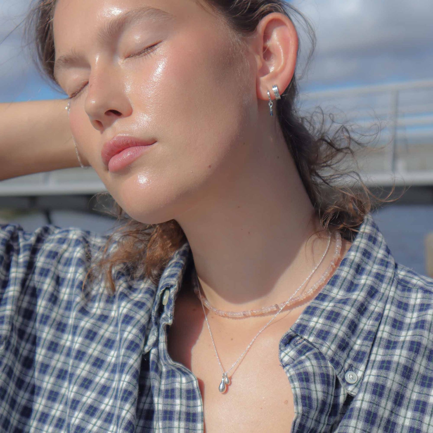 Woman wearing a blue plaid shirt with a blurred background