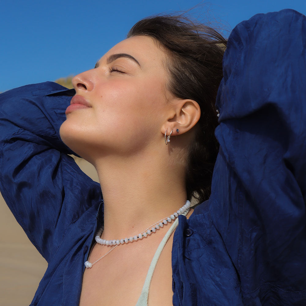 Woman wearing a blue jacket with a clear blue sky background