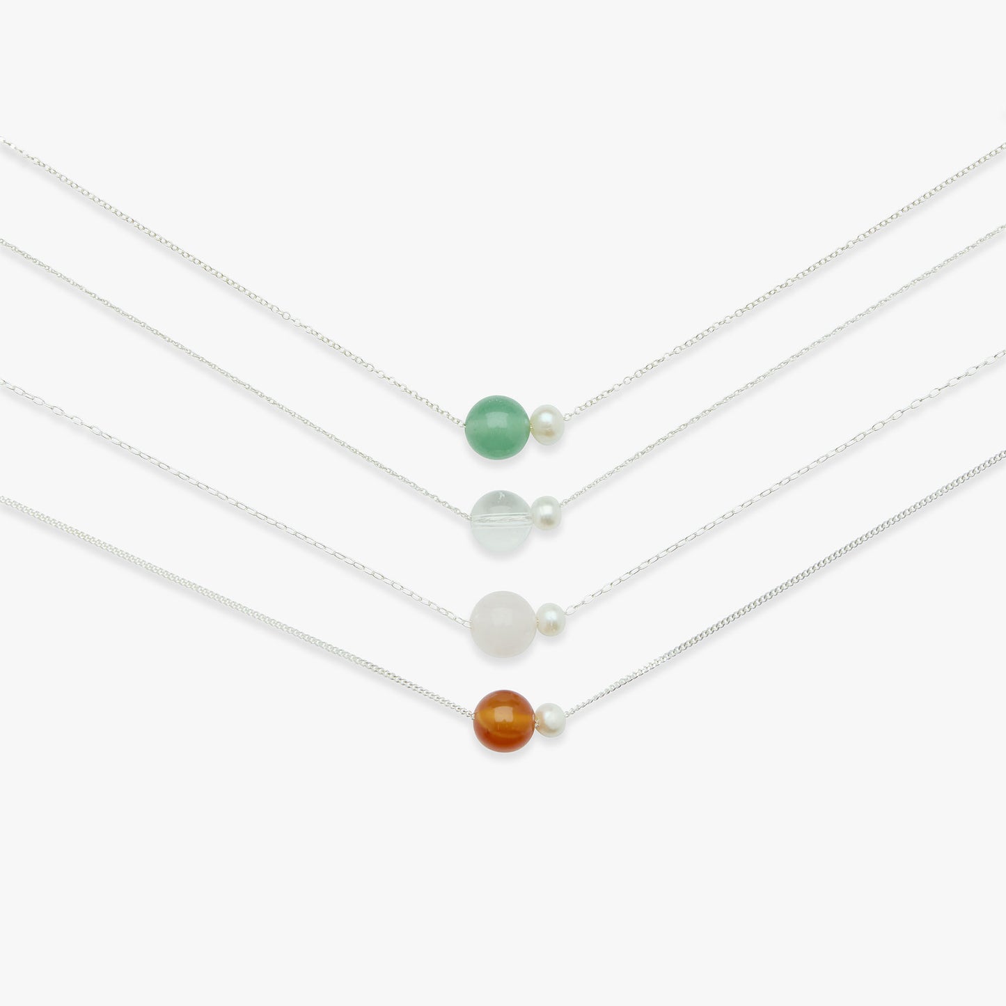 Set of four delicate necklaces with small beads on a white background