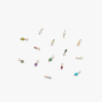 Collection of small jewelry charms on a white background
