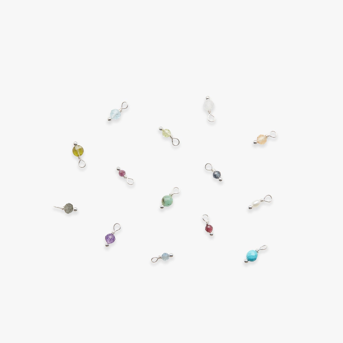 Colorful birthstone gemstone charms on a white background