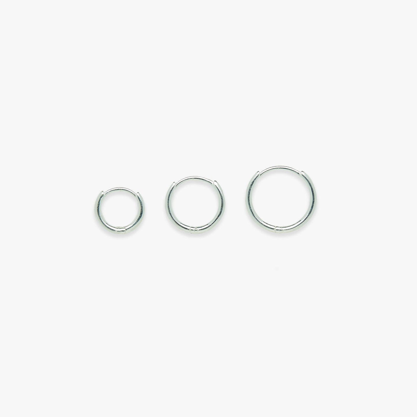 Three silver hoop earrings on a white background