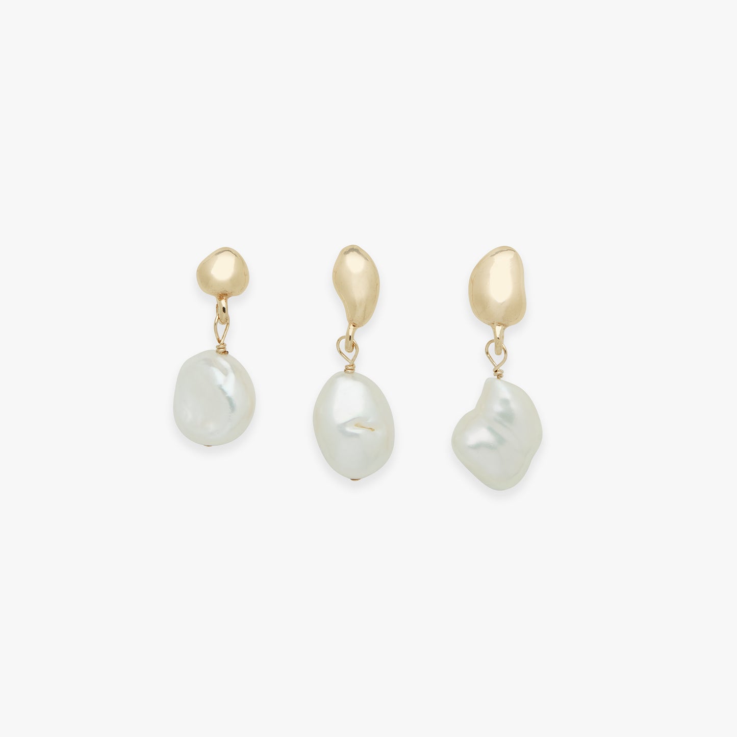 Three pearl earrings with gold clasps on a white background