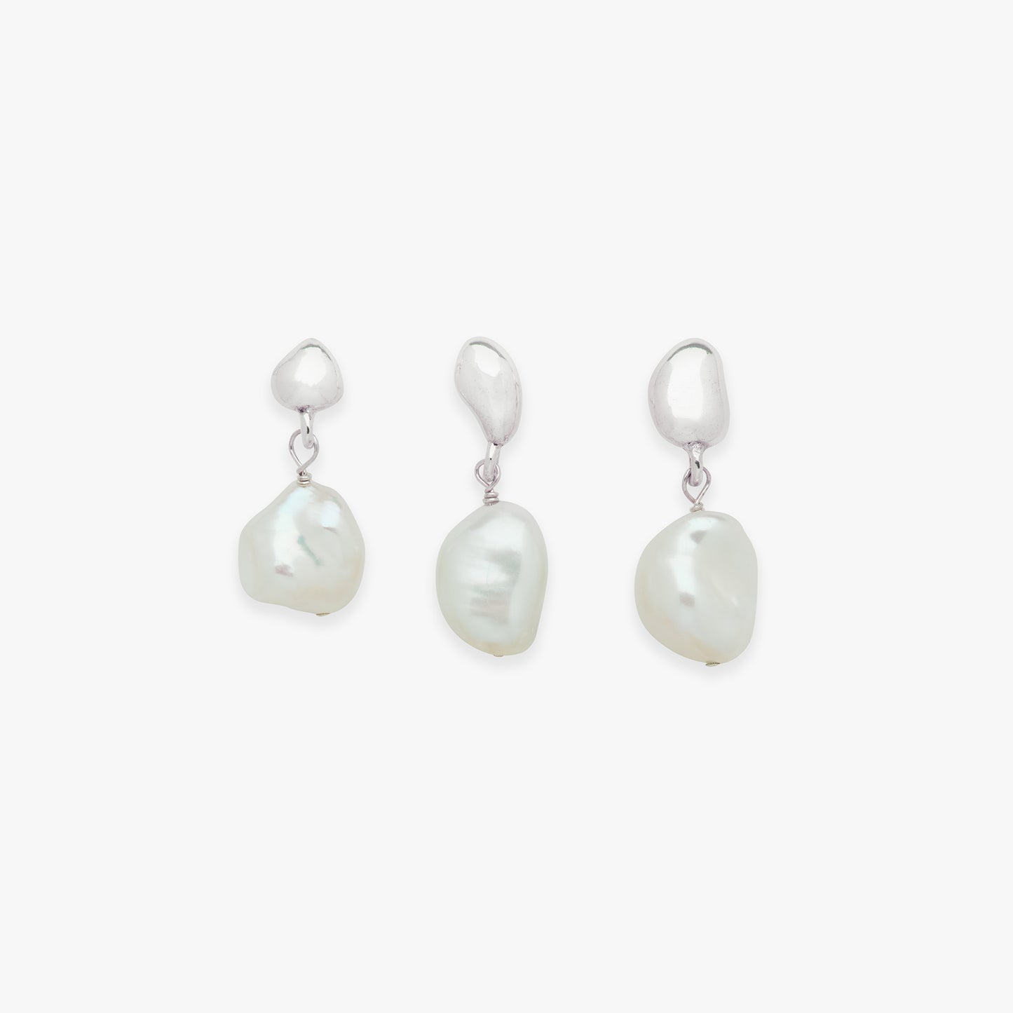 Three pearl drop earrings on a white background