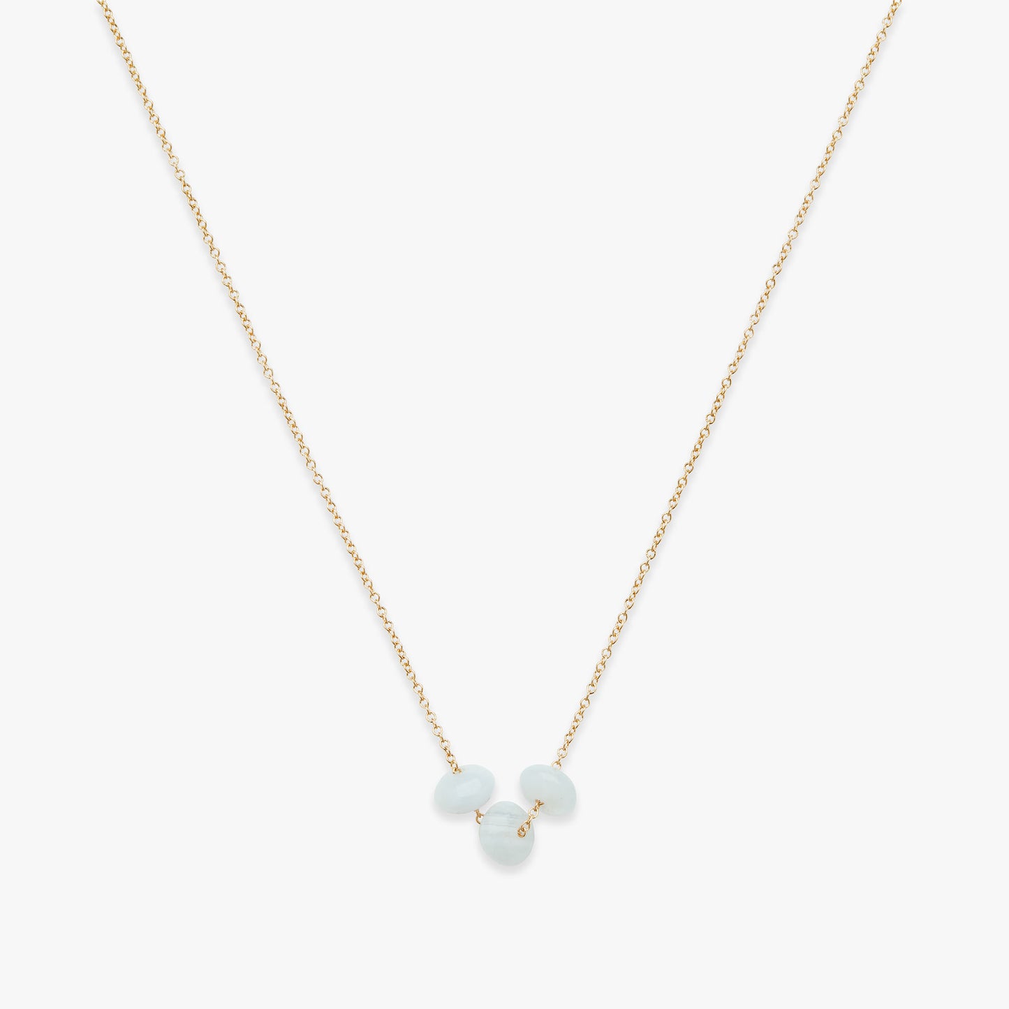 Gold necklace with three light blue beads on a white background