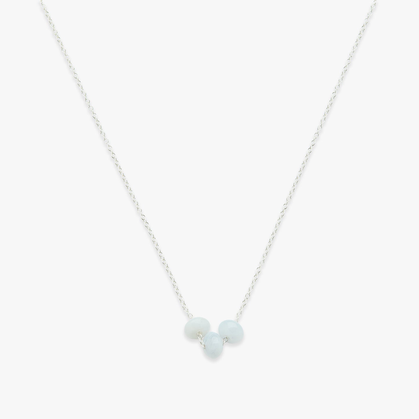 Necklace with three light blue beads on a thin chain against a white background