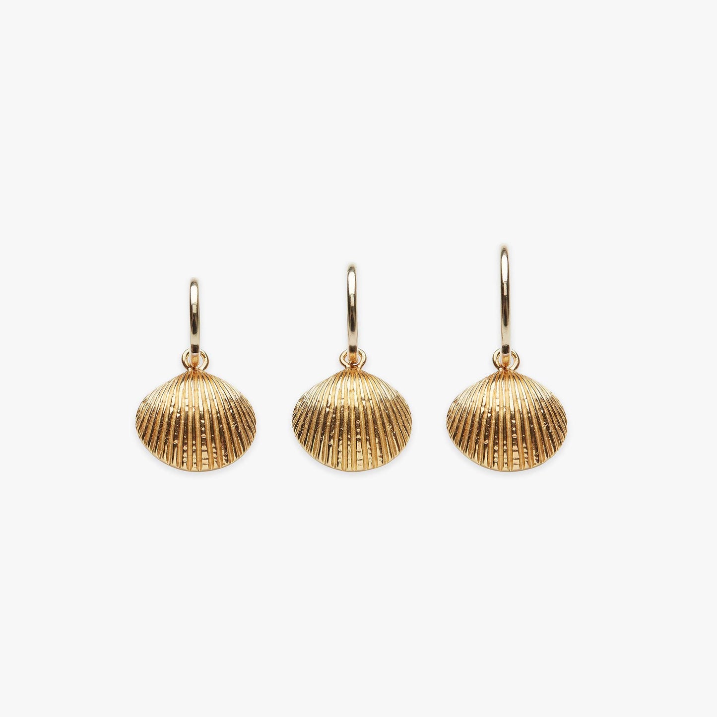 Three gold shell-shaped earrings on a white background