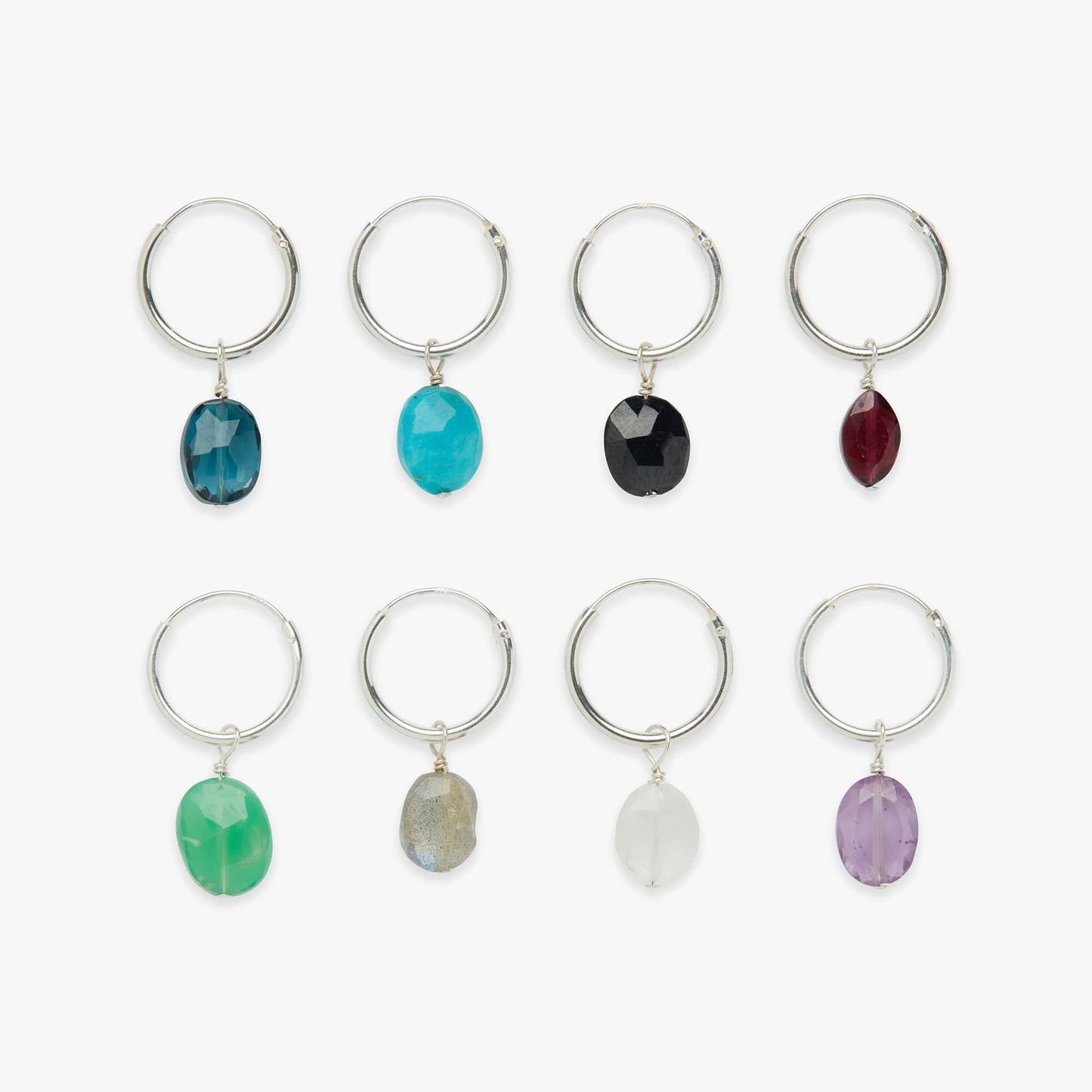 Set of eight silver earrings with colorful gemstones on a white background