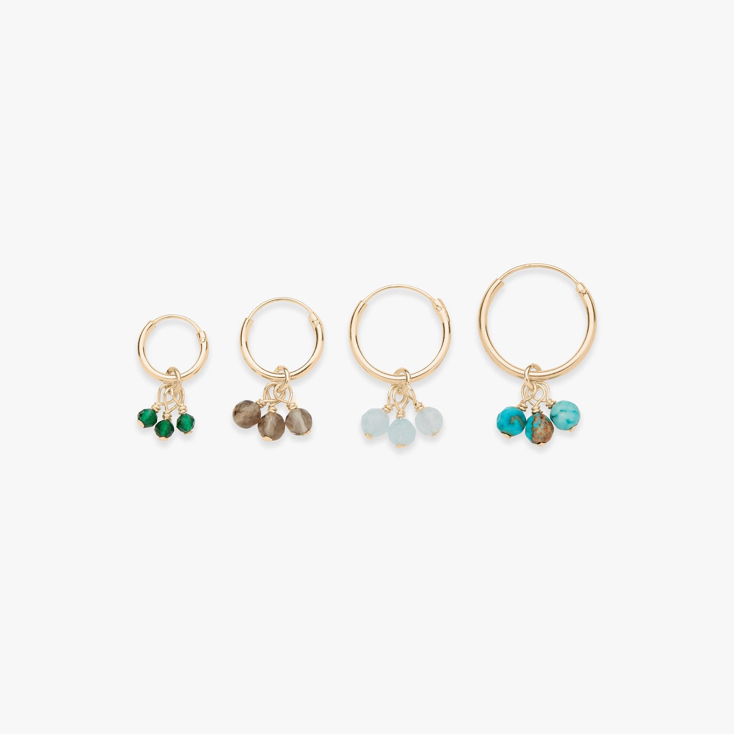 Set of four gold hoop earrings with various colored beads on a white background