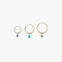 Three gold hoop earrings with colored stones on a white background