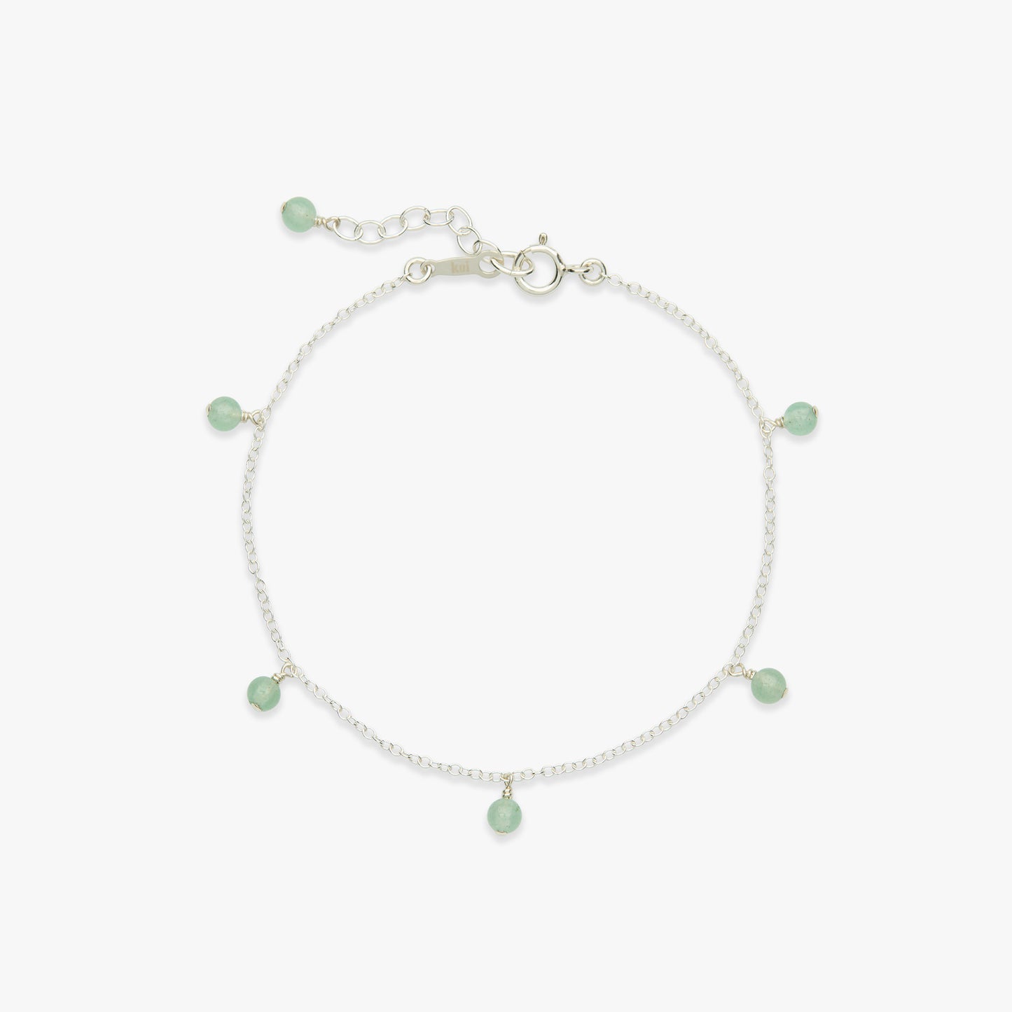 A delicate silver chain bracelet featuring five small, light green bead charms spaced evenly around the circle, displayed on a clean white background.