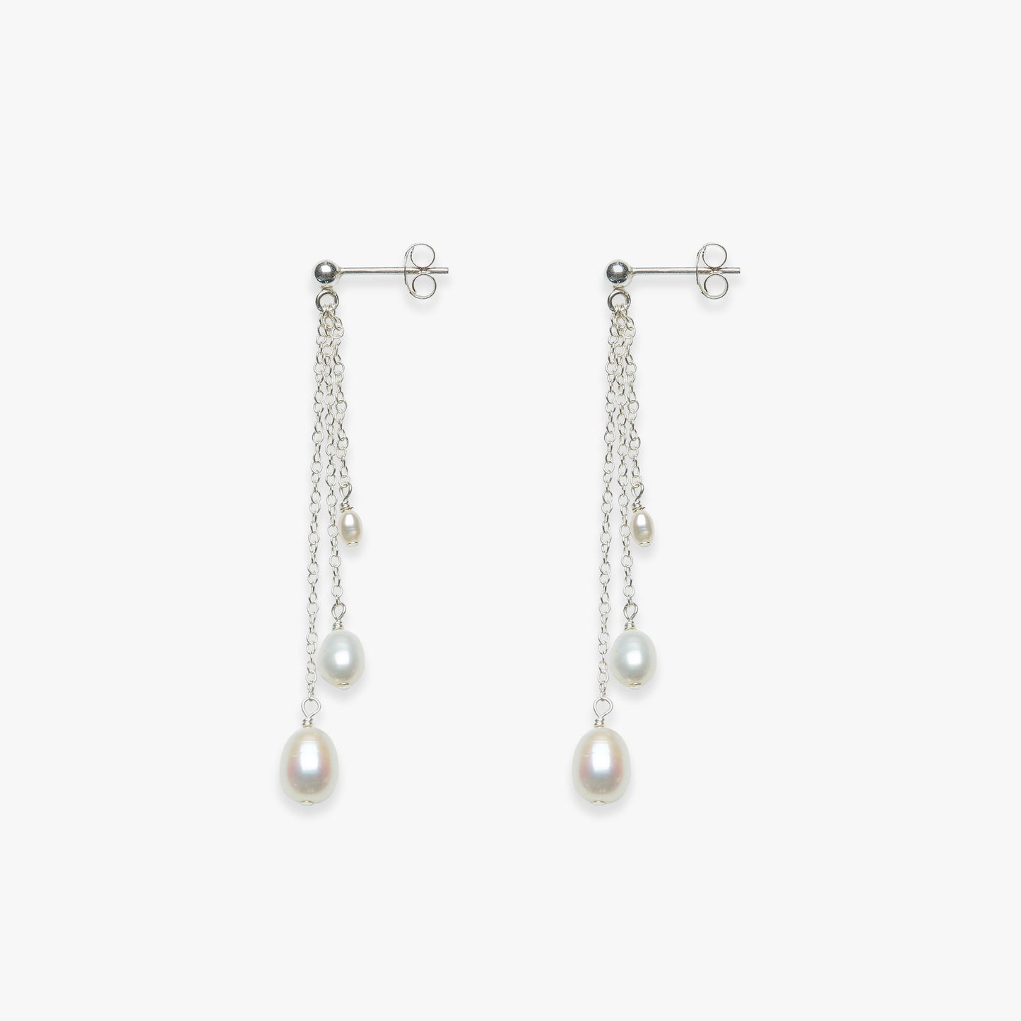 Pair of pearl earrings with chains on a white background
