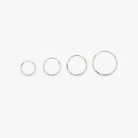 Set of four silver hoop earrings on a white background