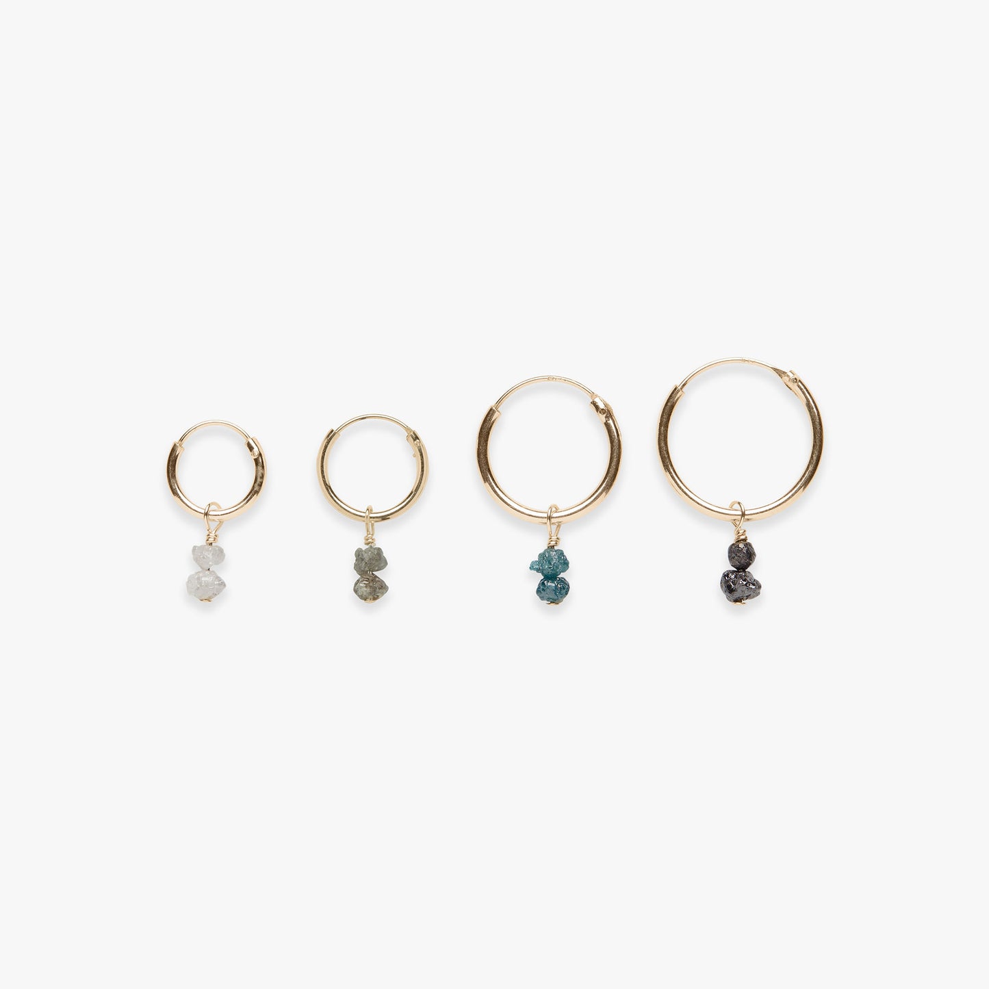 Four gold hoop earrings with stone drops on a white background