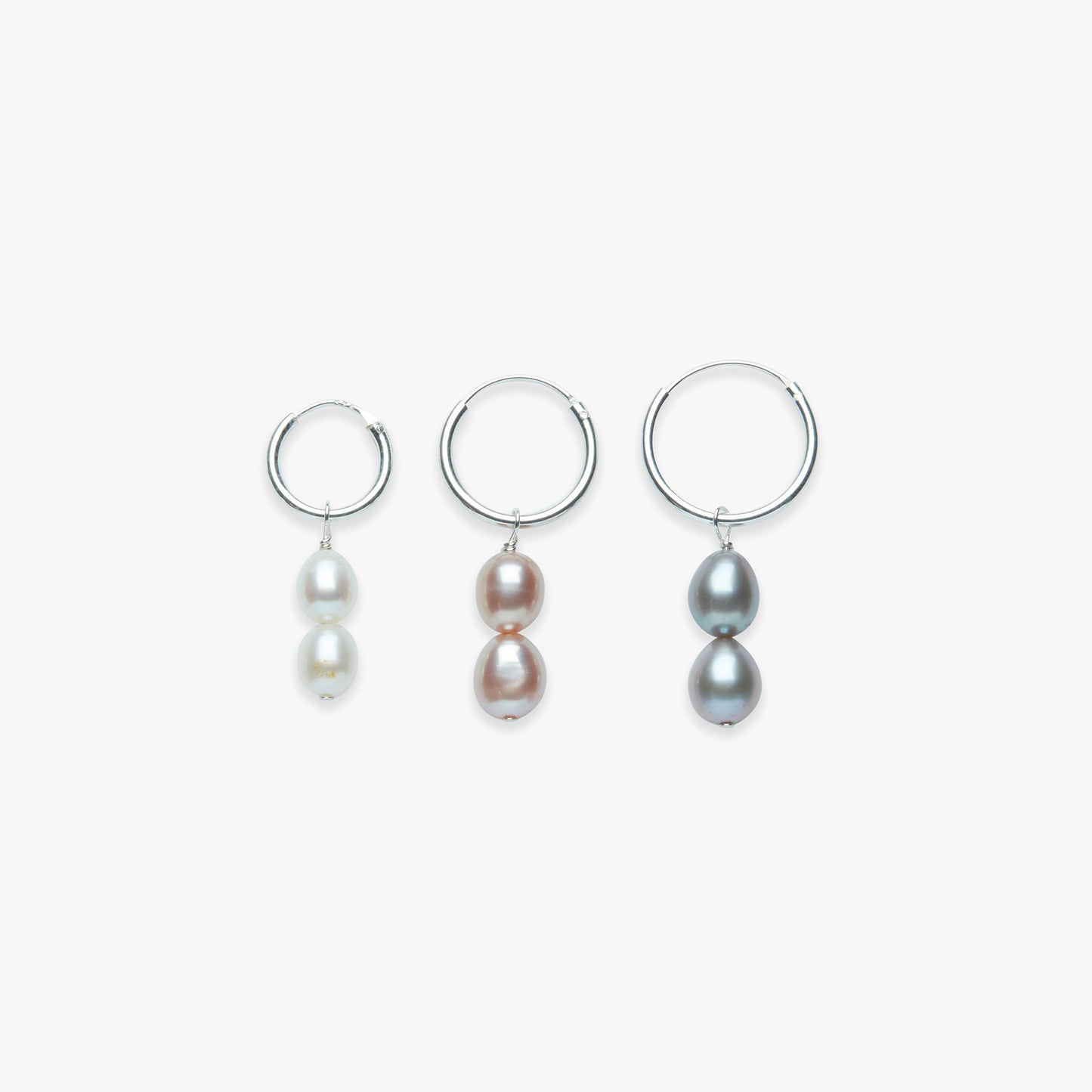 Three pairs of pearl earrings on a white background