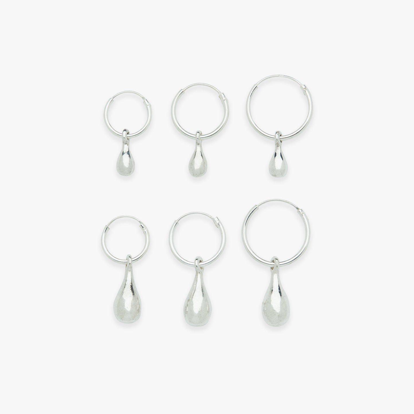 Set of six silver teardrop earrings on a white background