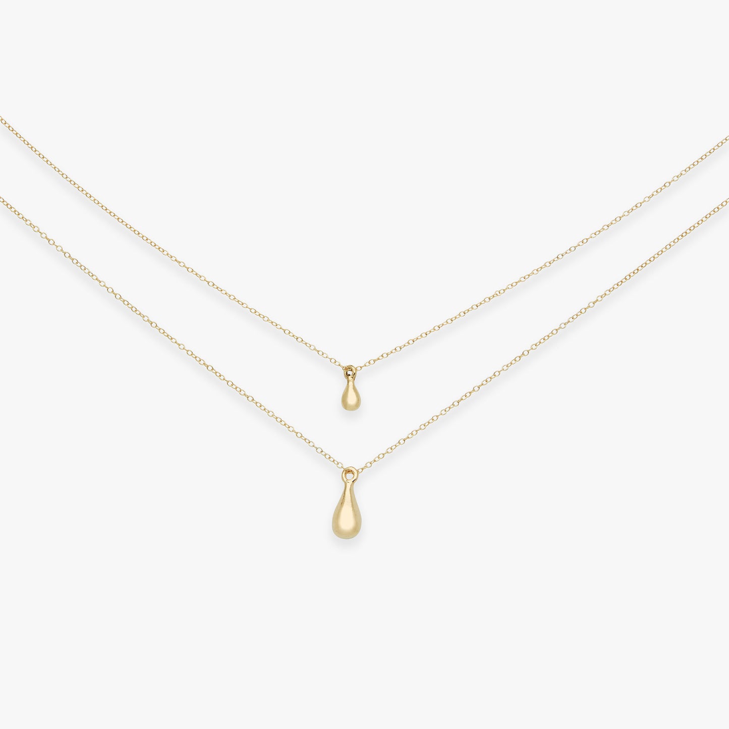 Two gold teardrop pendants on thin gold chains against a white background