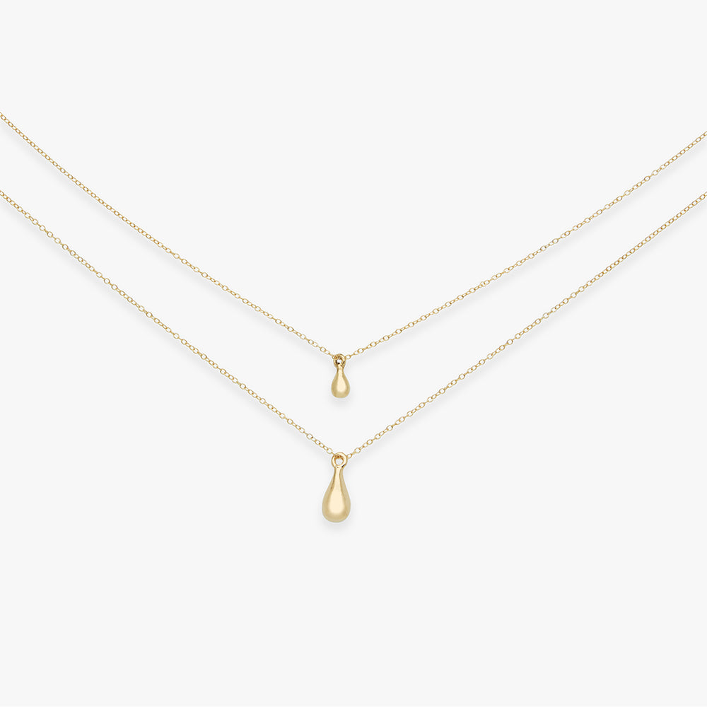 Two gold teardrop pendants on thin gold chains against a white background