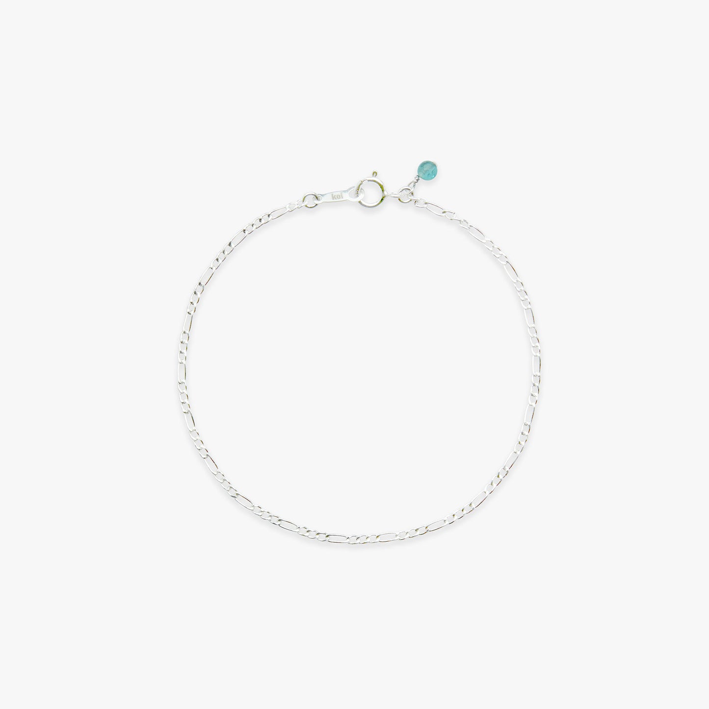 Silver bracelet with a small blue gemstone on a white background