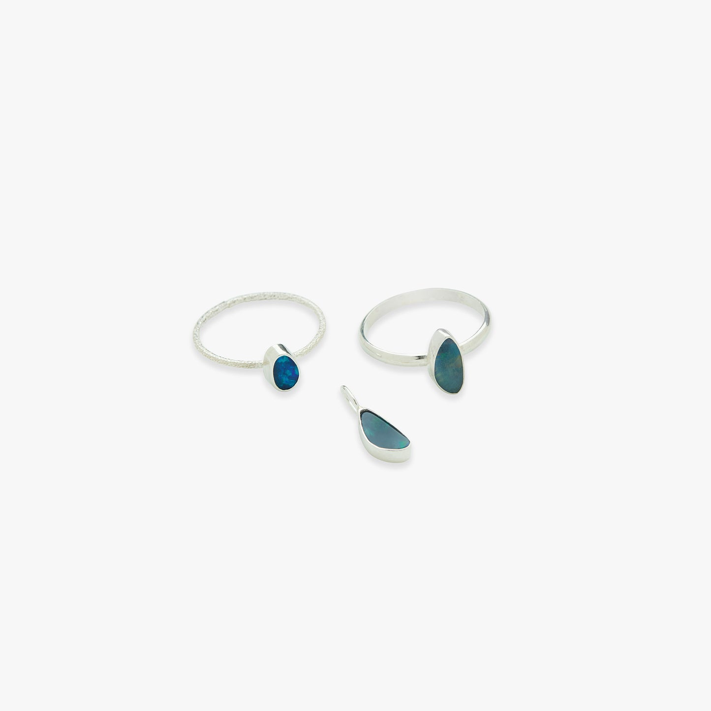 Two silver rings with blue stones on a white background