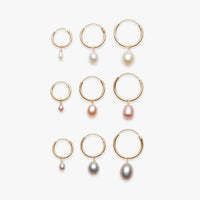 Set of gold hoop earrings with pearls on a white background