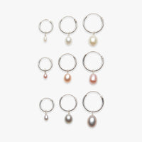 Set of silver hoop earrings with pearl drops on a white background