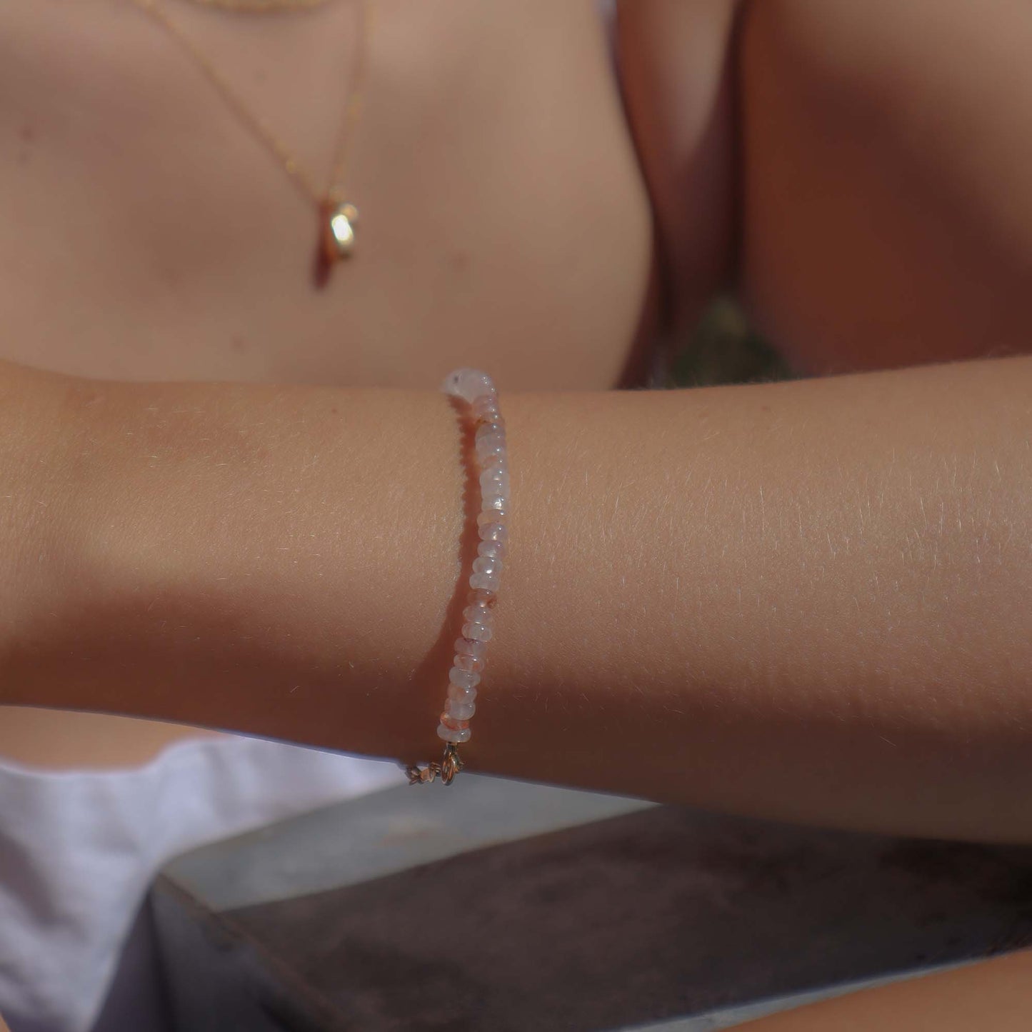 Close-up of a person's arm wearing a beaded bracelet with a blurred background