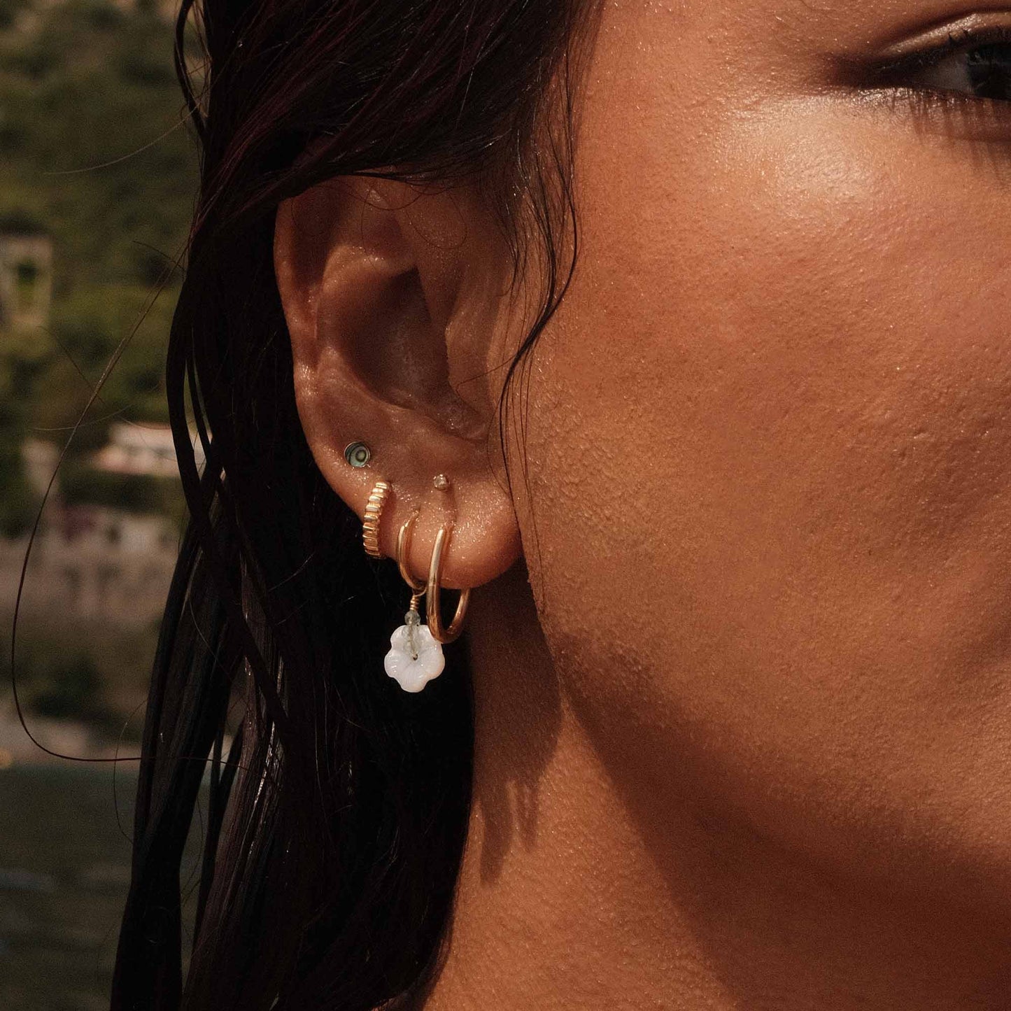 Close-up of a person's ear with earrings against a blurred background