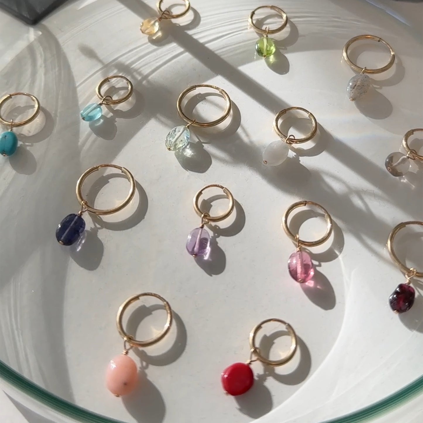 Gold rings with colorful beads on a white surface