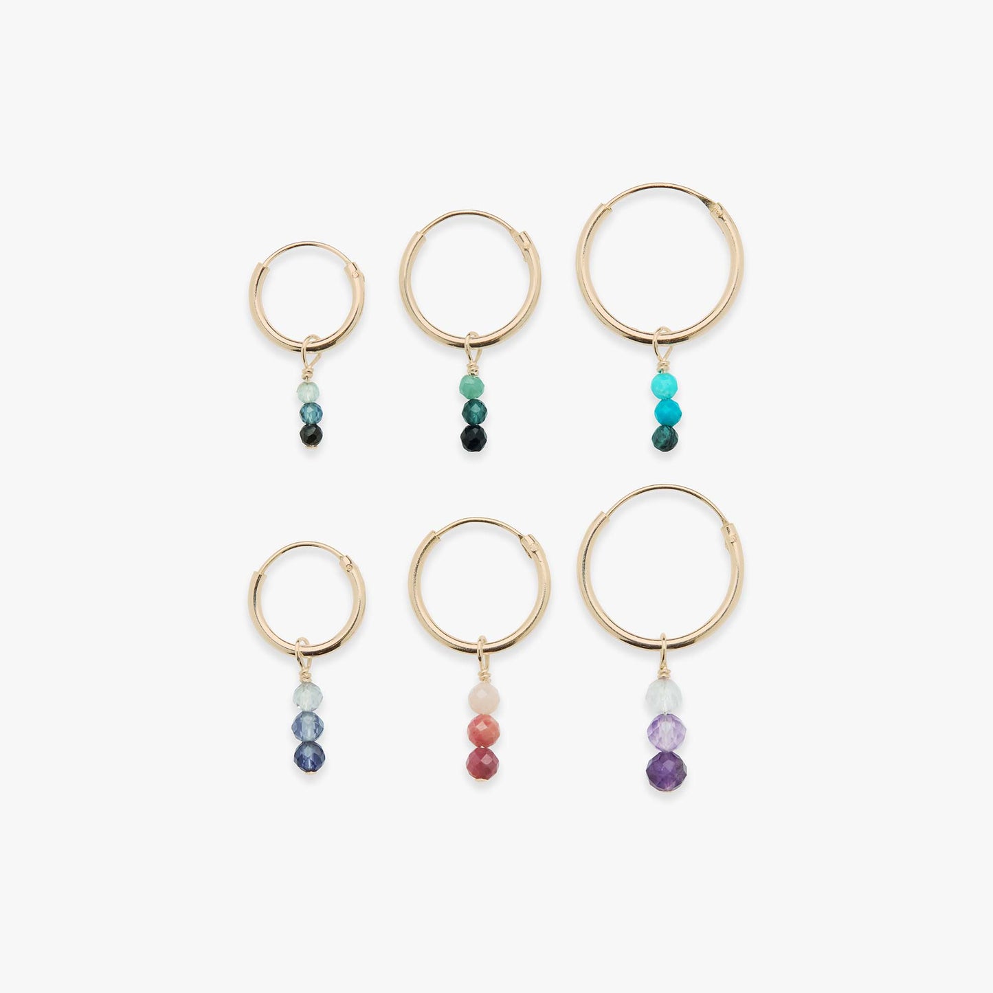 Set of gold hoop earrings with colorful beads on a white background