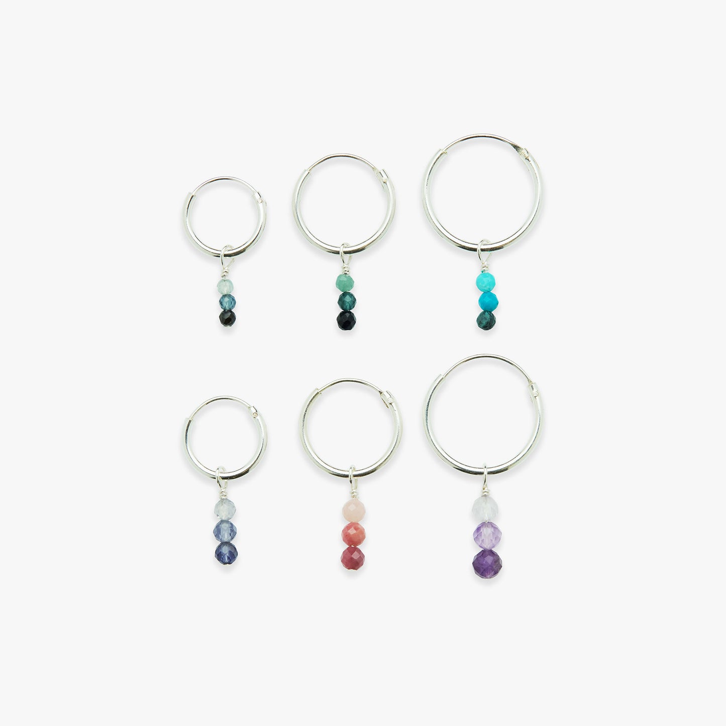 Set of six silver hoop earrings with colorful beads on a white background