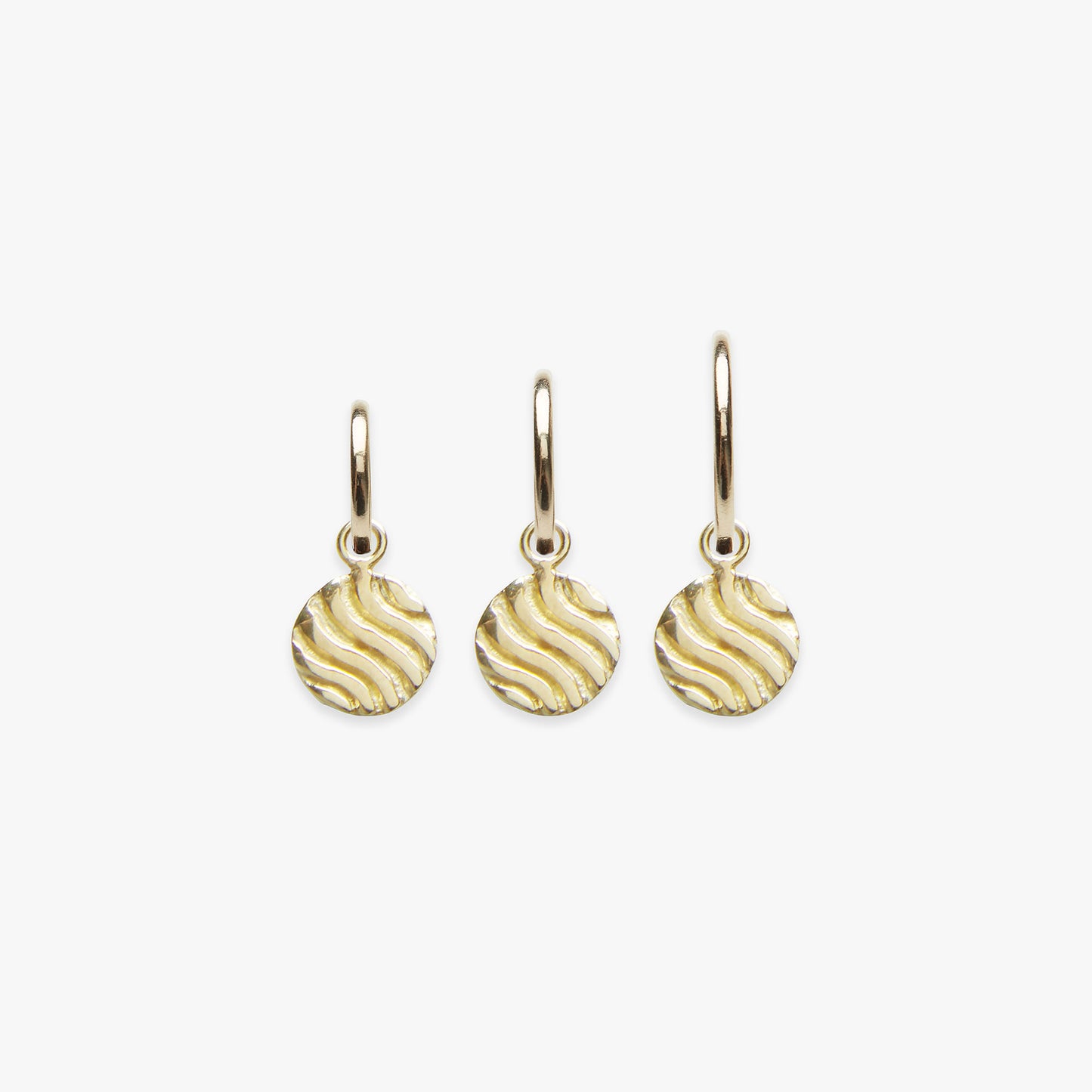 A set of three pendant earrings with a gold vermeil finish, featuring a textured design resembling sandy dunes.
