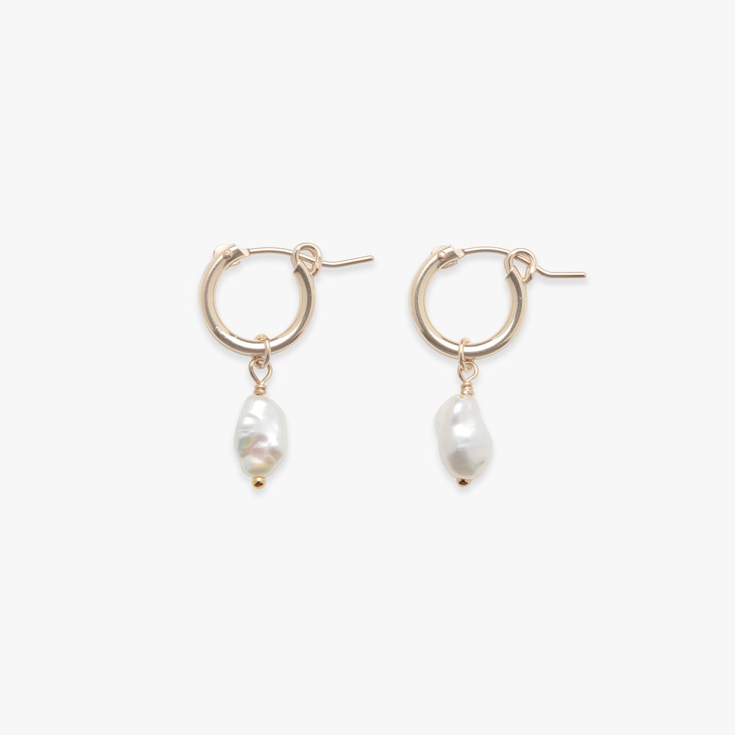 Pair of gold hoop earrings with pearl drops on a white background