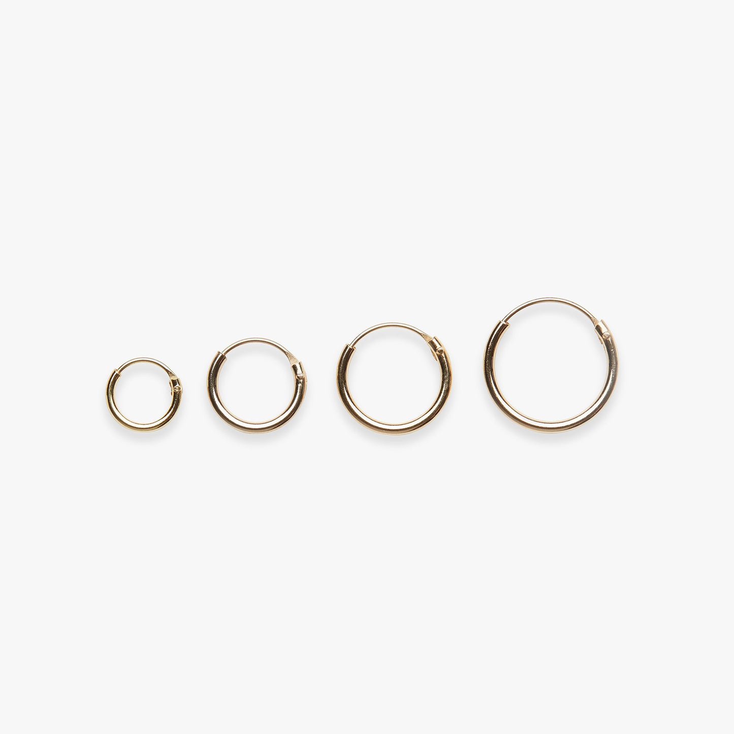 Set of gold hoop earrings on a white background