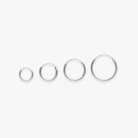 Set of four silver hoop earrings on a white background