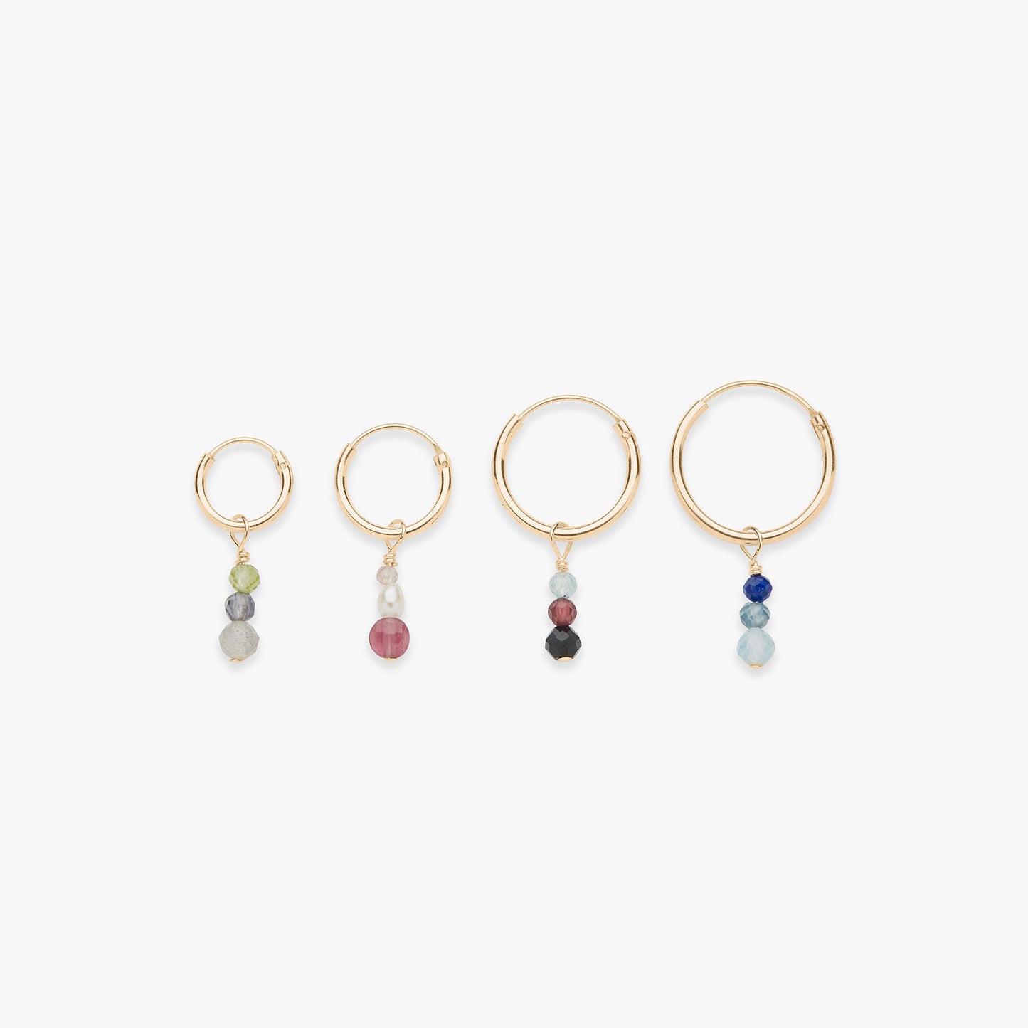 Set of four gold hoop earrings with colorful beads on a white background