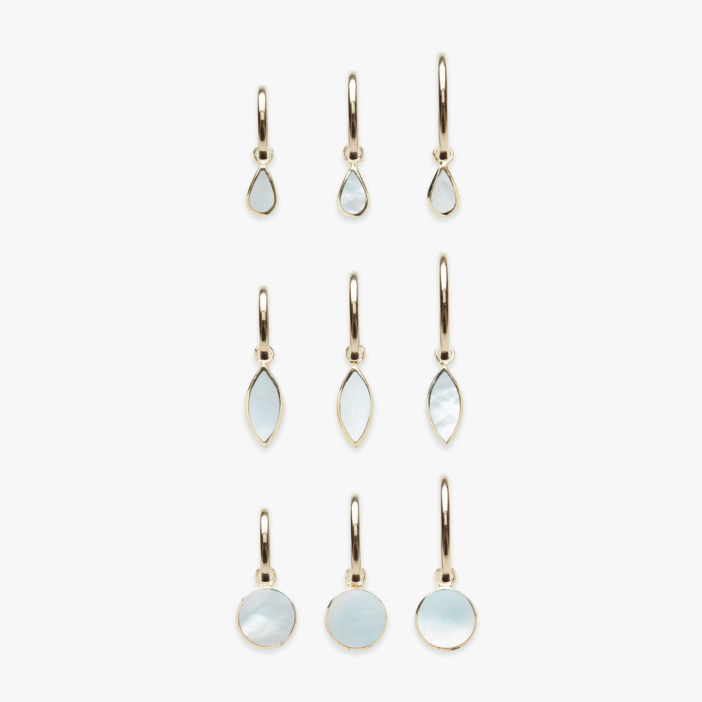 Set of gold earrings with white mother of pearl stones on a white background