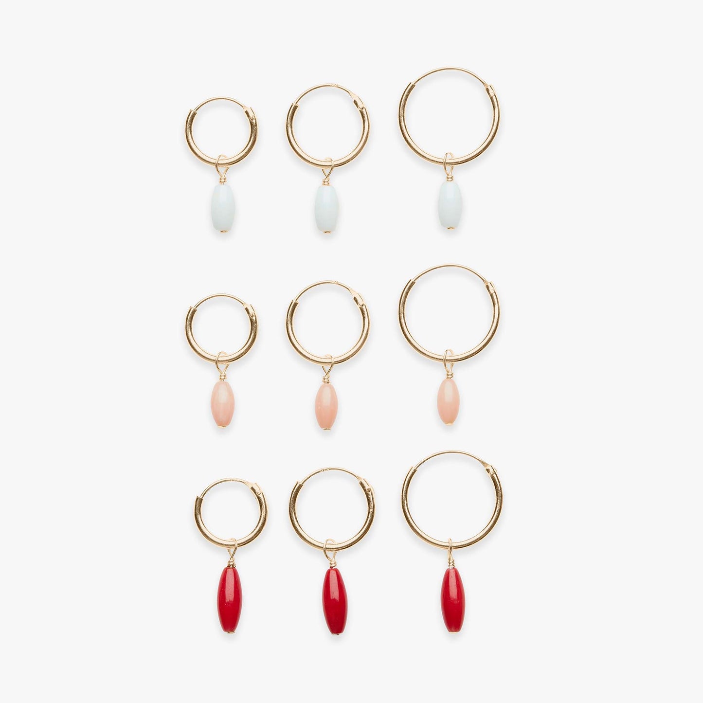 Set of gold hoop earrings with various colored beads on a white background