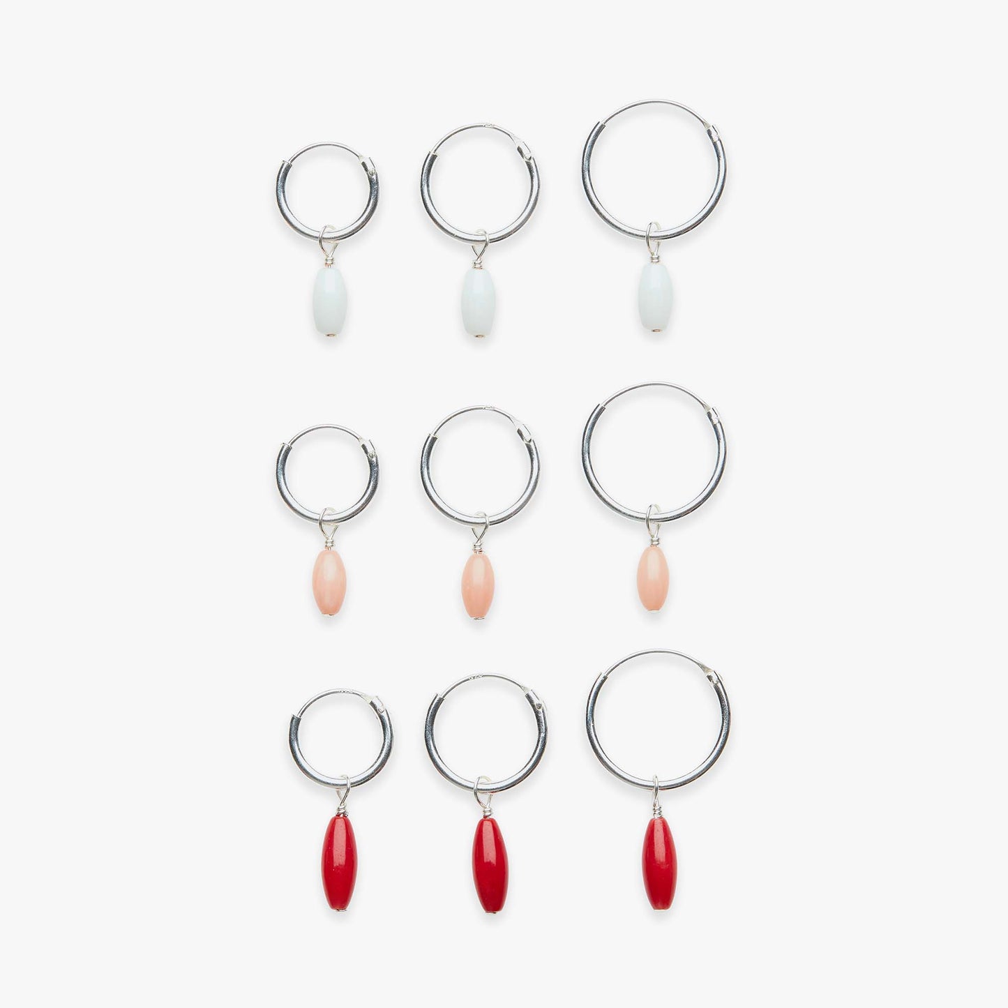 Set of hoop earrings with various colored drops on a white background