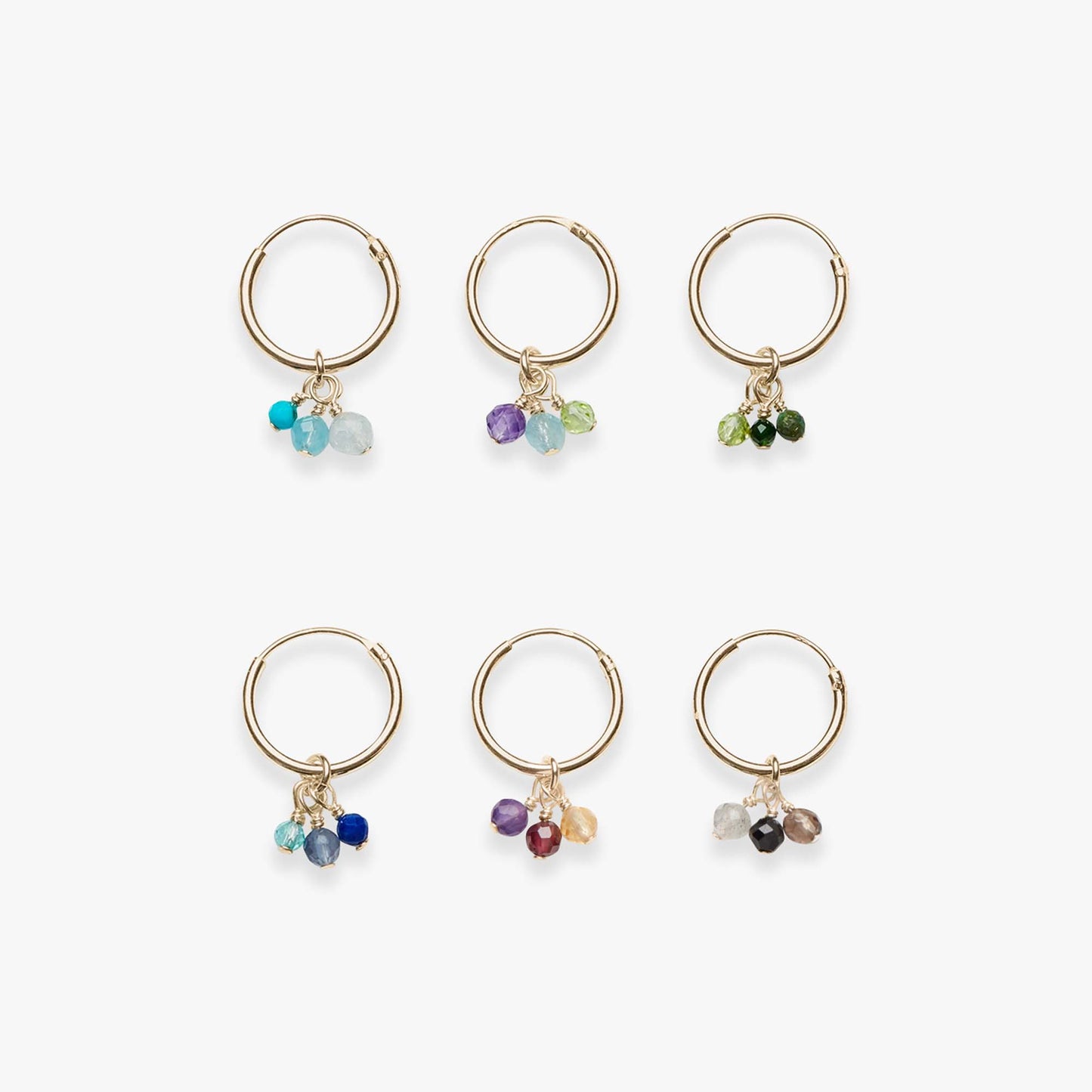 Set of six gold hoop earrings with colorful gemstone charms on a white background