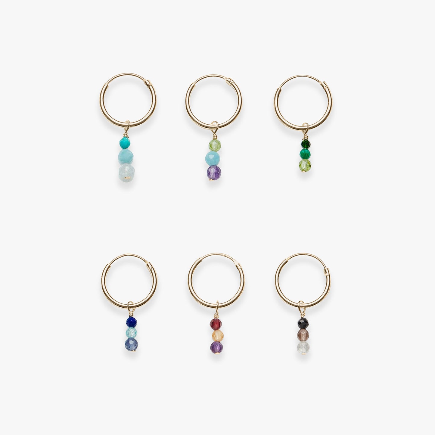Set of six gold hoop earrings with multicolored beads on a white background