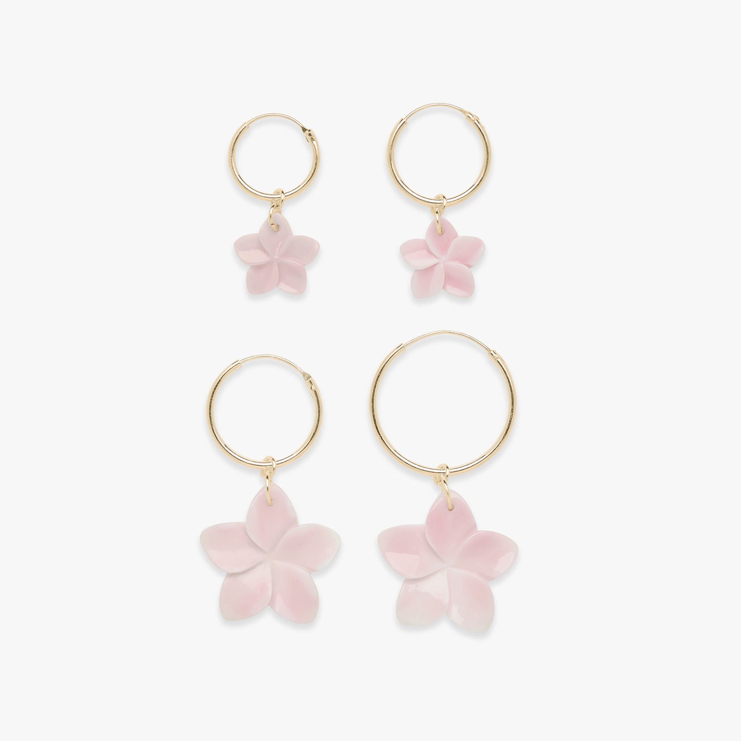Gold hoop earrings with pink flower charms on a white background